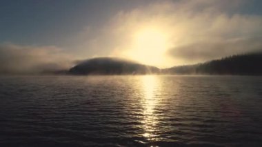 Göl üzerindeki sabah sisi, güneşin doğuşu..