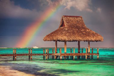 Rainbow over the  Wooden Water Villa  in Cap Cana, Dominican Republic. clipart