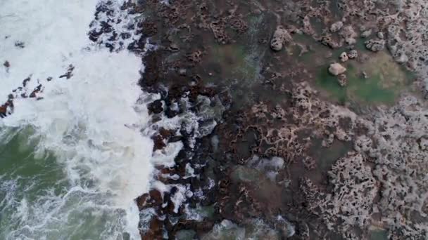 打ち寄せる波が岩の多い海岸線の空中写真 — ストック動画