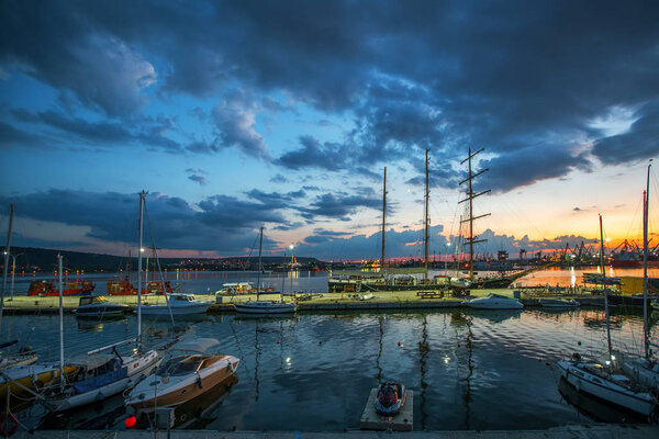Yacht port and beautiful sunset over Varna, Bulgaria. Sailboat harbor, many beautiful moored sail yachts in the sea.
