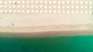 Sahilde hava üstten görünüm. Açık kum ve mavi deniz suyu. 