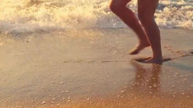 Adam sahilde koşuyor. Bacaklarını yıkama dalgalar deniz.