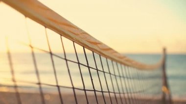 Voleybol ağı ve kumsalda güzel bir gün doğumu. 