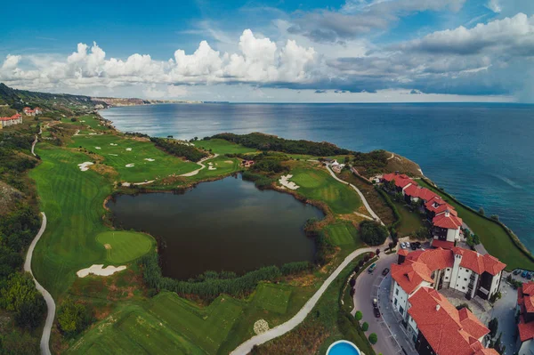 高尔夫球场在豪华度假村旁边的海崖 球场上的高尔夫球手鸟瞰图 — 图库照片