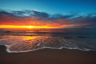 Güzel gündoğumu ve büyük kargo gemileri Karadeniz yelken plaj ve güneş ışınlarına karşı.