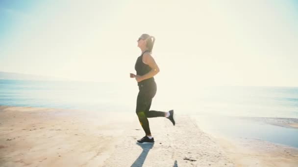 健康的年轻妇女在海边奔跑日出 — 图库视频影像