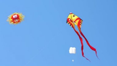 Renkli uçurtma uçan bir mavi gökyüzü ve güneş karşı