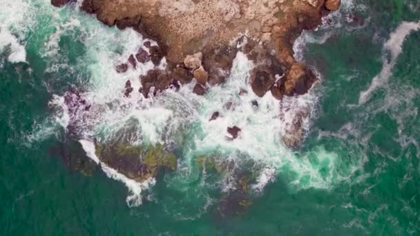 打ち寄せる波が岩の上に岩が多い海岸線の空中写真 — ストック動画