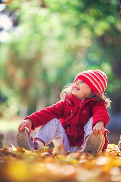 Schönes Kleines Mädchen Sitzt Fallendem Laub Herbstpark — Stockfoto