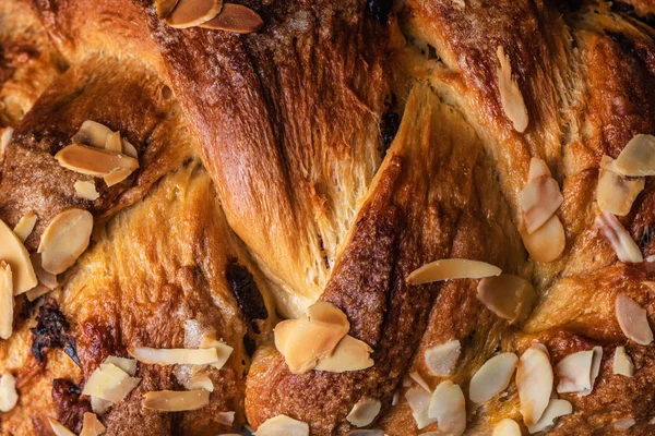 Freshly baked Easter bread with chocolate and almonds as background.