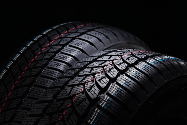 Winter Car tires on black background.