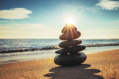 Plaj, gündoğumu atış taşlar bakiye. Zen meditasyon, yoga uygulamaları.