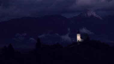 Jamnik, Slovenya - gece görünümü üzerinde Kilisesi, St. Primoz Slovenya Jamnik yakınındaki güzel bulutlar ve Julian Alps, arka plan.