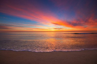 Sea sunrise and beautiful cloudscape over the beach and washing waves