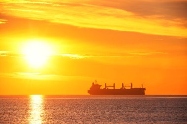 Kargo gemisi Yelkenli ile denize gündoğumu. Ulaşım. Lojistik. Nakliye.