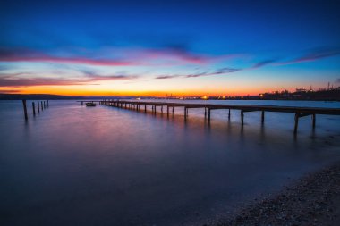Göldeki küçük rıhtım ve tekne, gün batımı çekimi.