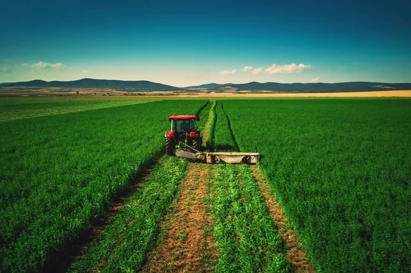 Traktor mäht grüne Wiese — Stockfoto