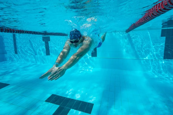 Подводные виды спорта, мужчина плавает в чистом бассейне — стоковое фото