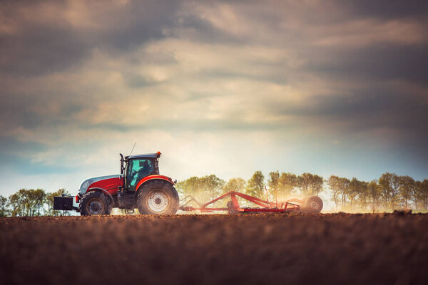 Фермер в тракторе готовит землю с семеноводителем