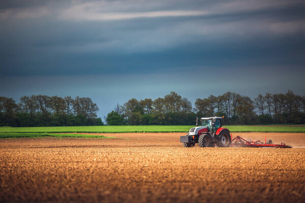 Фермер в тракторе готовит землю с семеноводителем