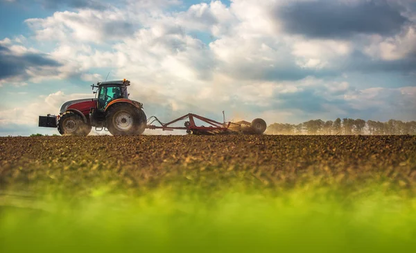 Agricoltore in trattore preparazione terreno con seminativo — Foto Stock