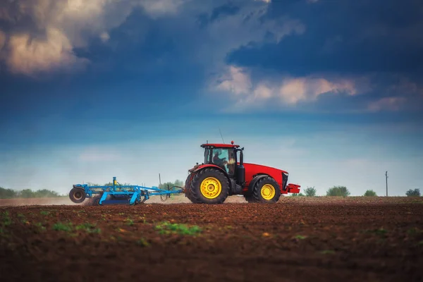 Agricultor en tractor preparando tierra con cultivador de semillero —  Fotos de Stock