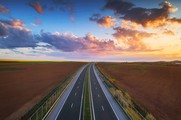 Aerial view of highway on sunset. Transportation background. Landscape with road near countryside fields. — Stock Photo, Image