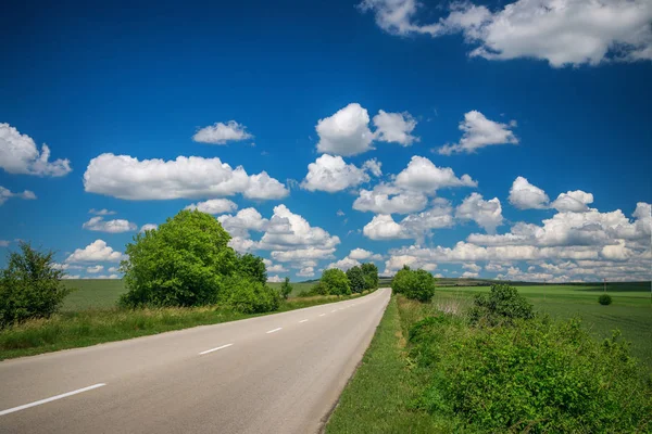 Pusta asfaltowa droga z zachmurzonym niebem — Zdjęcie stockowe