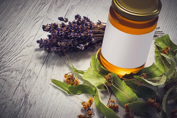 Mel em jarra com flores de lavanda e tília no fundo de madeira vintage — Fotografia de Stock