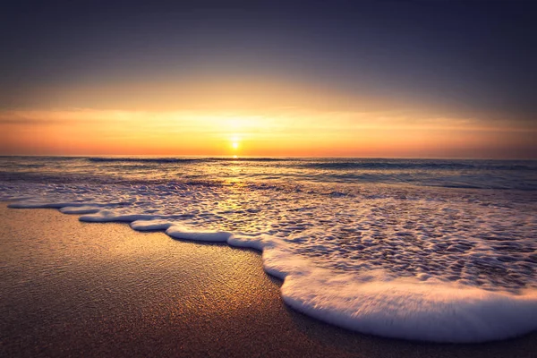 Napkelte felett a tengertől és a strandtól. Hullámok mosás homok — Stock Fotó
