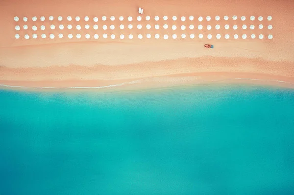 Vista aerea dall'alto sulla spiaggia. Ombrelli, sabbia e onde marine, trattore di pulizia — Foto Stock