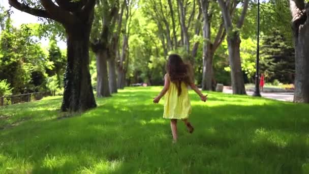 Ευτυχισμένο Μικρό Κορίτσι Κίτρινο Φόρεμα Τρέξιμο Ξυπόλητος Πράσινο Γρασίδι Στο — Αρχείο Βίντεο
