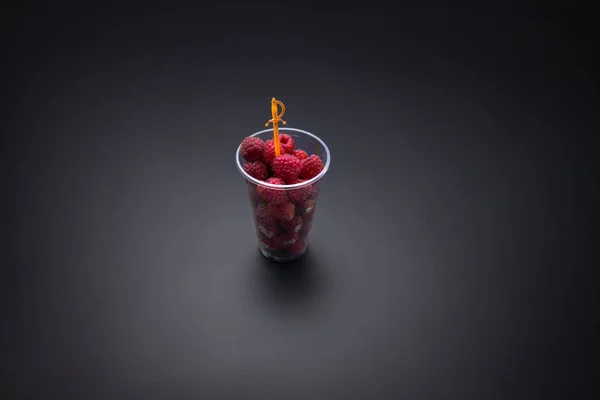 Свежая малина с вилкой для вечеринок в чашке, изолированной дорожкой для обрезки — стоковое фото