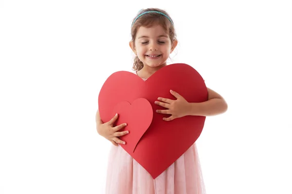 Feliz niña sostiene tarjetas en forma de corazón en sus manos. Amor, soñar — Foto de Stock