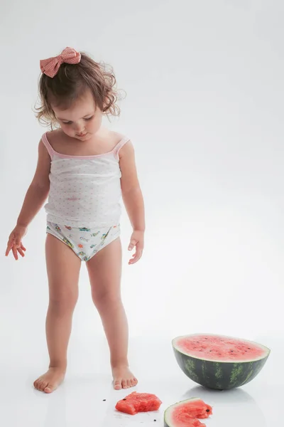 흰색 배경에 고립 된 수박 슬라이스를 먹는 아기 소녀 — 스톡 사진
