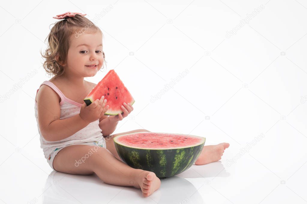 Baby girl eating watermelon slice isolated on white background