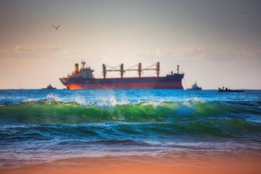 Yelkenli kargo gemisi ve gün doğumunda dalgalar. Ulaşım. Logisti