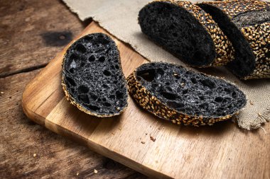 Ahşap tahta üzerinde ev yapımı ekşi hamur ekmek baget. Yemek, pişirme.