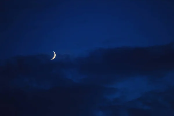 A lua mostrando contra o céu azul com nuvens — Fotografia de Stock