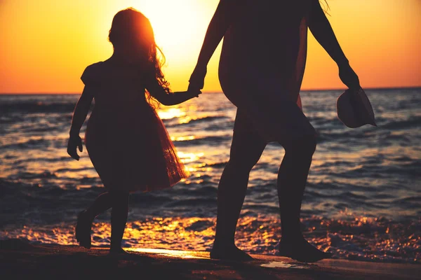 Mor och dotter leker tillsammans på havet stranden vid solnedgången — Stockfoto