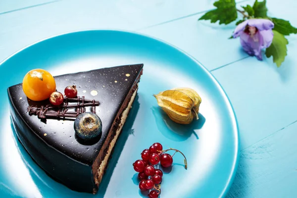 Pastel de chocolate con decoración y frutas sobre fondo de madera azul —  Fotos de Stock