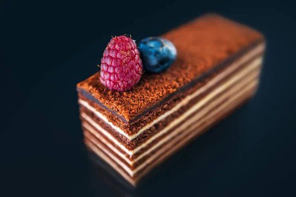 蛋糕片巧克力与牛奶奶油和水果隔离在黑色背景 — 图库照片