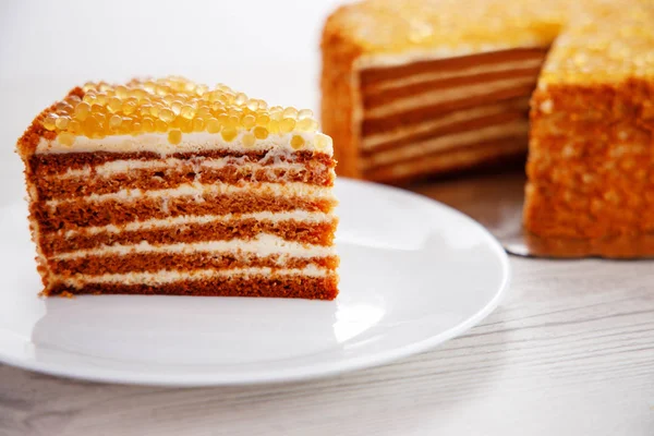 蜂蜜蛋糕与金珍珠和香草奶油隔离在白色 — 图库照片