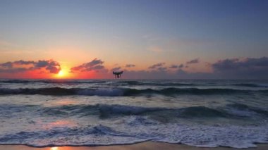 Tropik plaj ve güzel deniz gündoğumu. Dramatik bulutlar ve dans dalgaları.