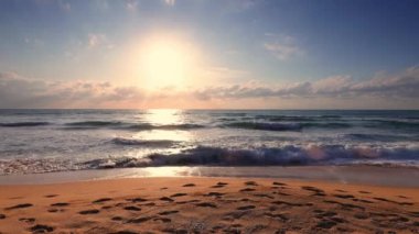 Tropik plaj ve güzel deniz gündoğumu. Dramatik bulutlar ve dans dalgaları.