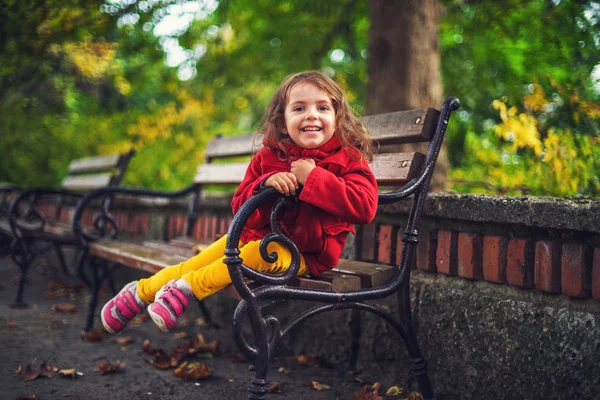 Vacker liten flicka i en höst park — Stockfoto