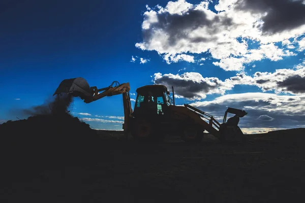 Wiellader graafmachine met veld achtergrond tijdens grondverzet — Stockfoto