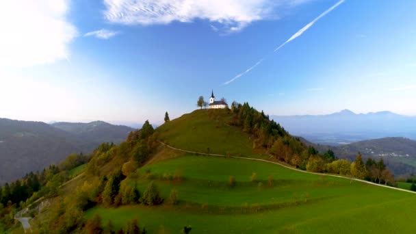 背景には ヤムニク スロベニア ジュリアン アルプス近くの聖プリモス教会の風景の空中ビュー — ストック動画