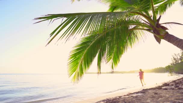 太阳升起在热带岛屿的海滩上 在海滩上奔跑的女孩 — 图库视频影像