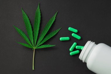 Esrar, marihuana yaprakları ve siyah üzerine izole edilmiş ilaç hapları